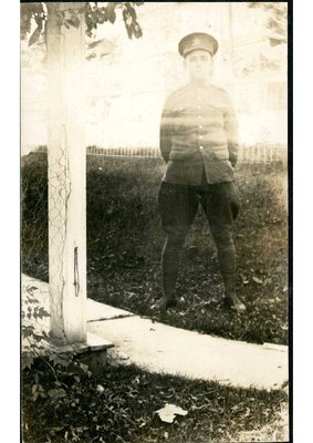 Photograph of a soldier in dress uniform standing on the grass