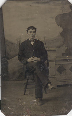 Young Man Seated in Front of Background