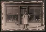 Storekeeper (tentatively identified as J.R. Dargavel) in front of general store in Elgin c.1905