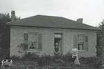 Man and Woman With Rural Brick Home, c. 1902-1906