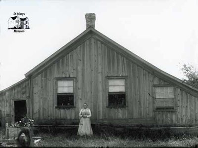 Woman with Board and Batten Farmhouse, c. 1902-1906