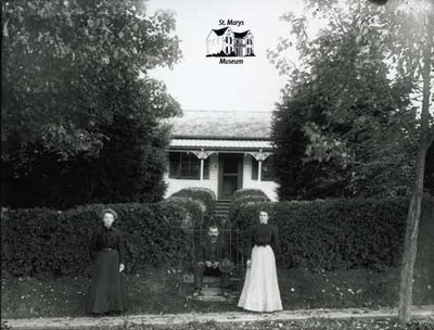 Two Women and a Man Posing with Small House, c. 1902-1906