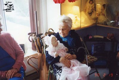 Elderly Woman Cradles Doll