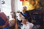 Elderly Woman Cradles Doll