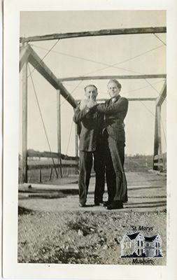 Two Men Standing on a Bridge