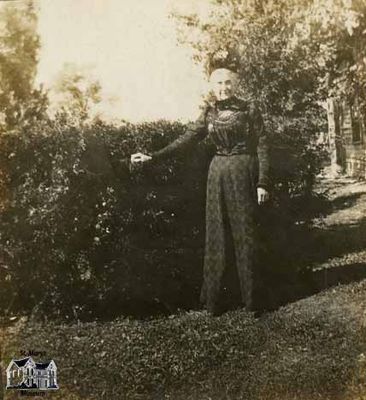 Woman Standing in Front of a Hedge