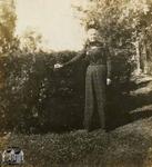 Woman Standing in Front of a Hedge