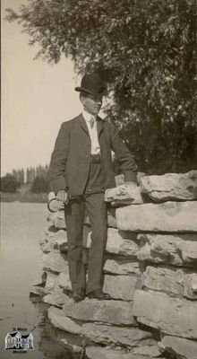 Man Standing on Rock Ledge Beside Water