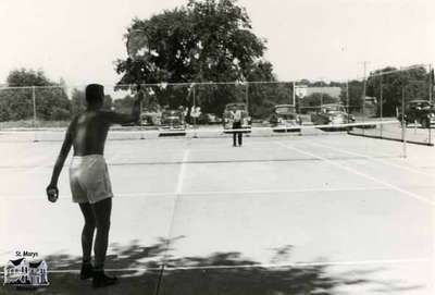 Two men playing at the tennis courts, ca. 1950