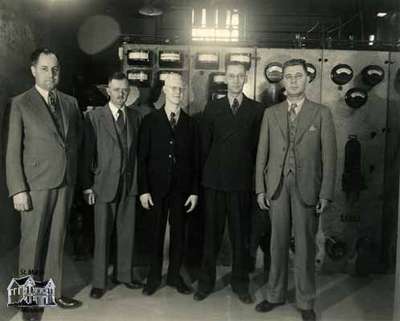 Five men standing in front of a transformer, 1936