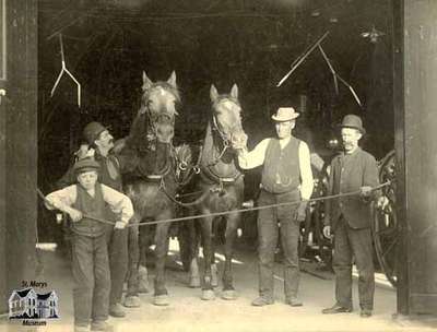 Three men and boy with horses