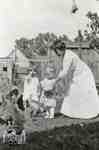 Woman with children feeding chickens