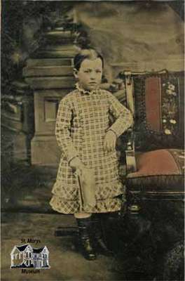 Child standing beside chair