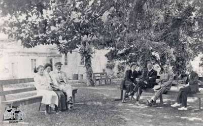 Group of people sitting on benches at &quot;Island Park&quot;