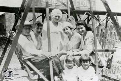 5 women and 2 children posed on garden swing