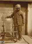 James (Jimmy) Tate standing beside his rocking chair