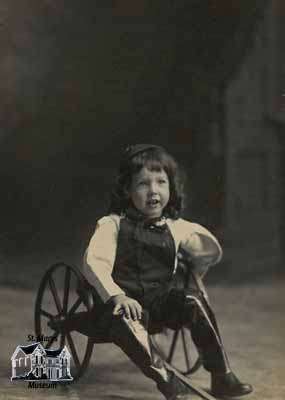 Boy sitting in two-wheeled cart