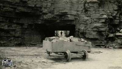 Cart at bottom of quarry with tunnel that connects quarries visible