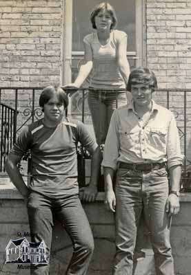 Two young men and one young woman standing outside