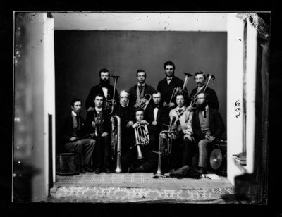 Group portrait of 11 men with musical instruments.