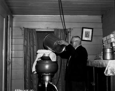 Unidentified Older Man Using a Cream Separator