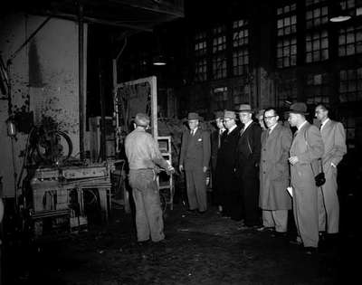 Men in Suits Visit a Factory