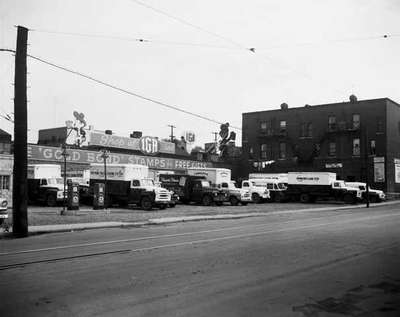 IHC Trucks, belonging to the Koffman Truck Leasing System, in front of an IGA.