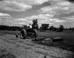 An IHC Farmall 400 tractor with 10' disk harrows.