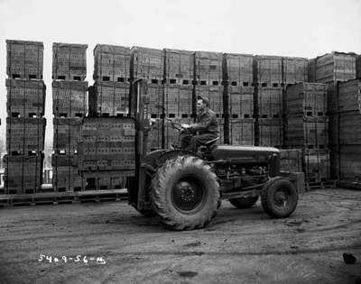 An IHC 300 tractor with a Kirkhof fork lift attachment, moving bricks.