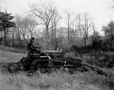 Clearing land with an IHC TD-5 crawler tractor and tractor front mounted dozer blades.