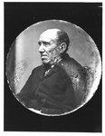 Portrait of seated elderly man with sideburns.