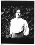 Outdoors portrait of young woman in white blouse.