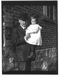 Outdoors portrait of John Connon holding a young girl.