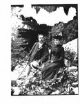 Portrait of unidentified man and woman seated on a river bank