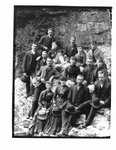 Group portrait of unidentified men and women seated on rocks.