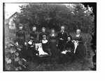 Family portrait, outdoors, with small stone building in background