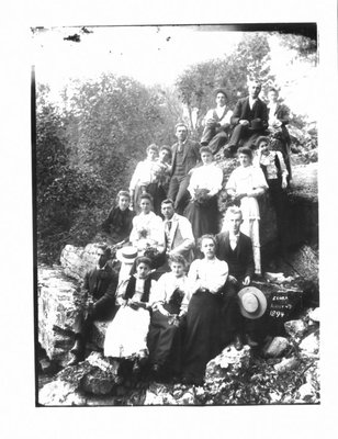 Group portrait of unidentified men and women on a rocky river bank in Elora.