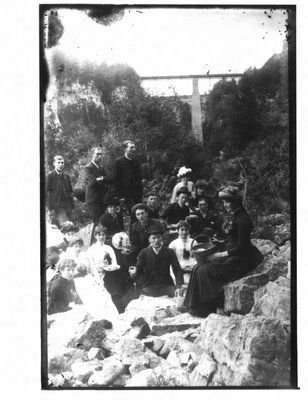 Group on a rocky river bank with the bridge over the Irvine River in the background