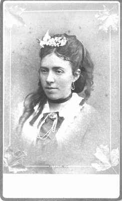 Bust portrait of an unidentified young lady with flowers in her hair.