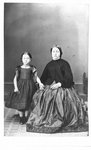 Portrait an unidentified young girl, standing, and an unidentified woman, sitting.