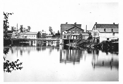 View of Elora, with wooden bridge over river.