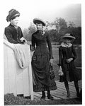 Outside portrait of a woman and two girls, standing on a boardwalk.
