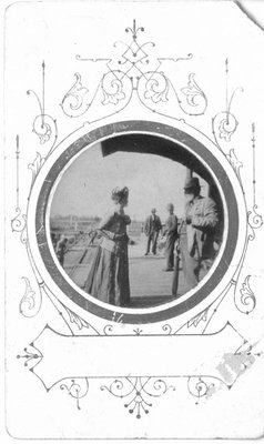 Four people on a railroad station platform.