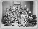 Group portrait of young women and girls holding Indian clubs.
