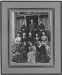 Group portrait of unidentified women and 2 men, on the front stoop of a building.