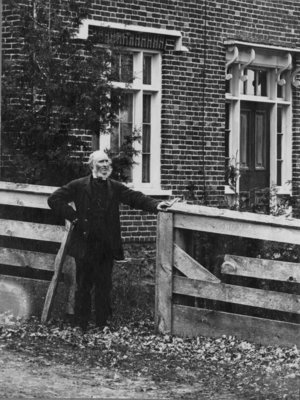 Outdoor portrait of James Moir, standing by a fence.