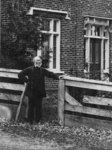 Outdoor portrait of James Moir, standing by a fence.