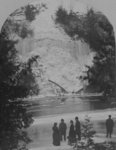 Winter view of Elora Gorge, with a group of men and women on the riverbank, in the foreground.
