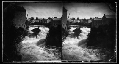 Photograph of stereograph card with 2 images of Elora showing the Grand River with &quot;the Tooth of Time&quot; a portion of the mill; and houses in the background.