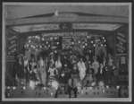 Cast of men and women in costume on stage of Armoury Hall, Elora